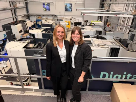 two founders of factory maker with the interior of factory behind them
